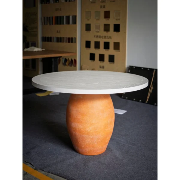 Terracotta Urn-Base Round Dining Table in rust — in a room setting