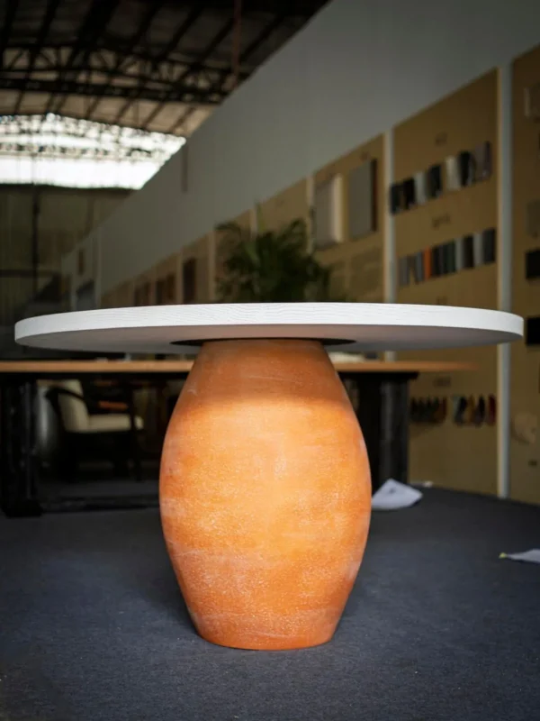 Terracotta Urn-Base Round Dining Table in rust — in a room setting