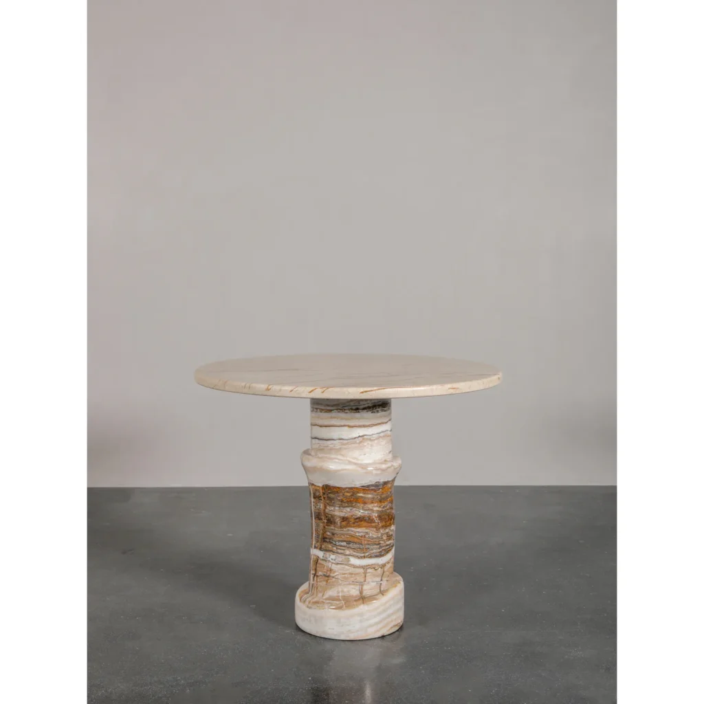 Cream Stone Round Side Table on Layered Onyx Column Base in oatmeal — in a room setting