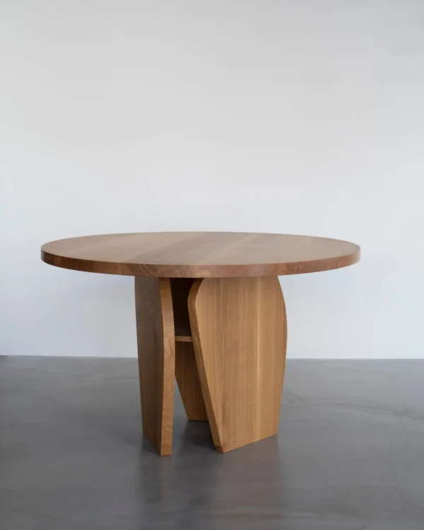 White Oak Round Leisure Table on Curved Panel Base in natural oak — in a room setting