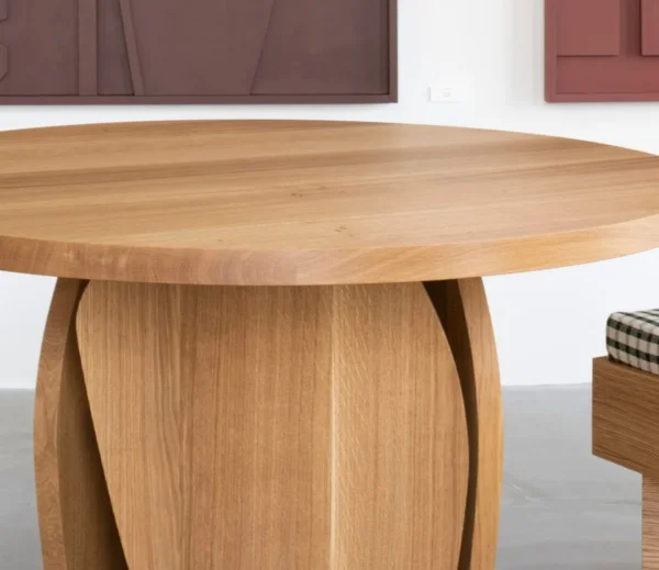 White Oak Round Leisure Table on Curved Panel Base in natural oak — in a room setting