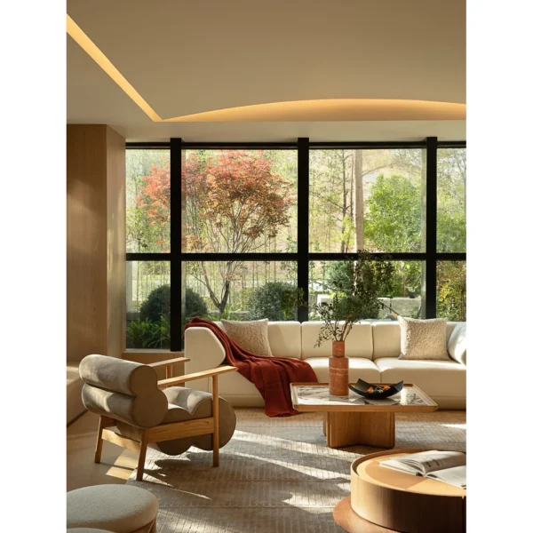 Low Oak Lounge Chair with Olive Leather Roll Cushions in natural oak — in a room setting