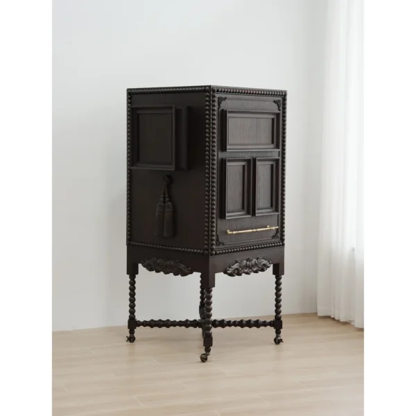 Carved Sequence Cabinet on Barley-Twist Legs with Tassels in black — in a room setting