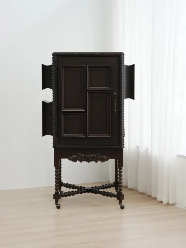 Carved Sequence Cabinet on Barley-Twist Legs with Tassels in black — in a room setting