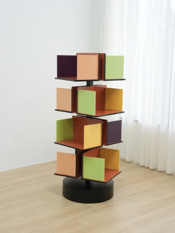 Rotating Multicolour Cube Bookcase on Black Base in multicolour — in a room setting