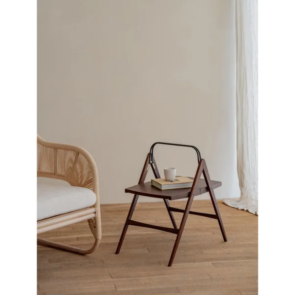 Yuban Folding Wood Side Table with Black Metal Handle in walnut — in a room setting