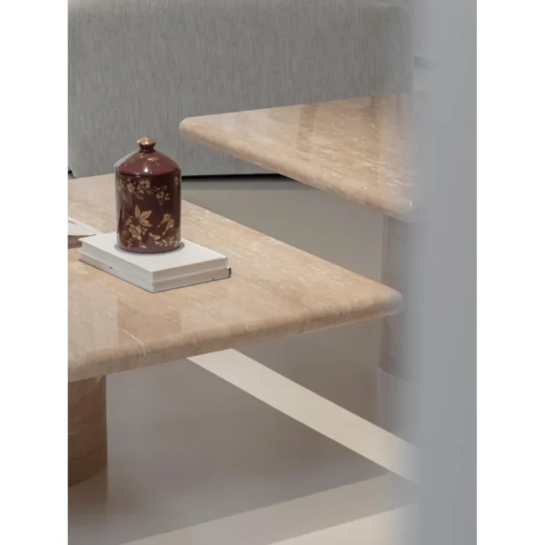 Yuexin Travertine Coffee Table Pair on Cylinder Bases in sand — in a room setting