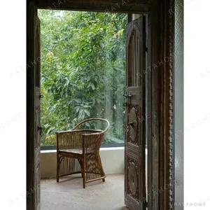 Natural Rattan Armchair with Suspended Back in natural oak — in a room setting