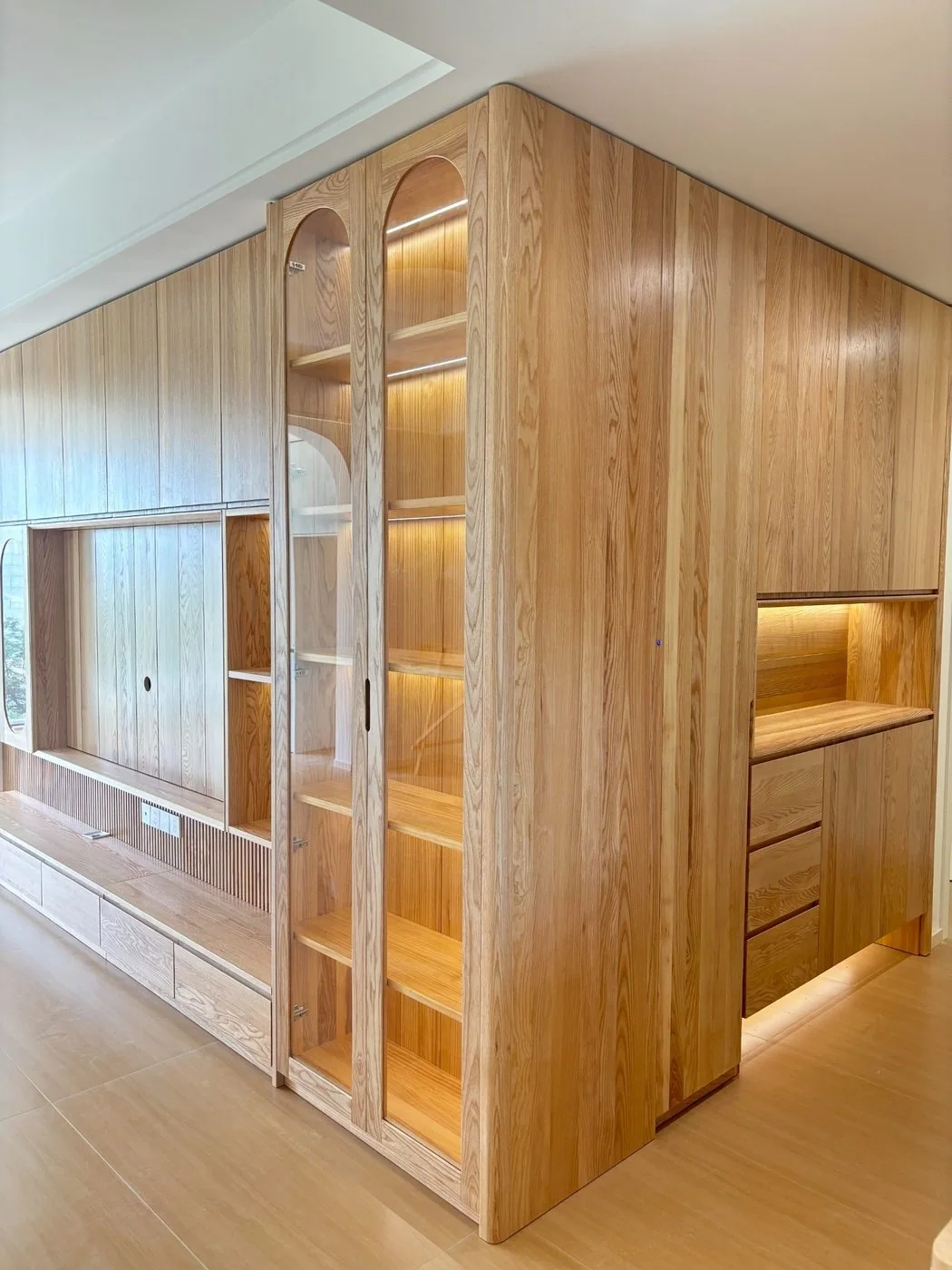 Full-height ash built-in cabinetry with illuminated shelving