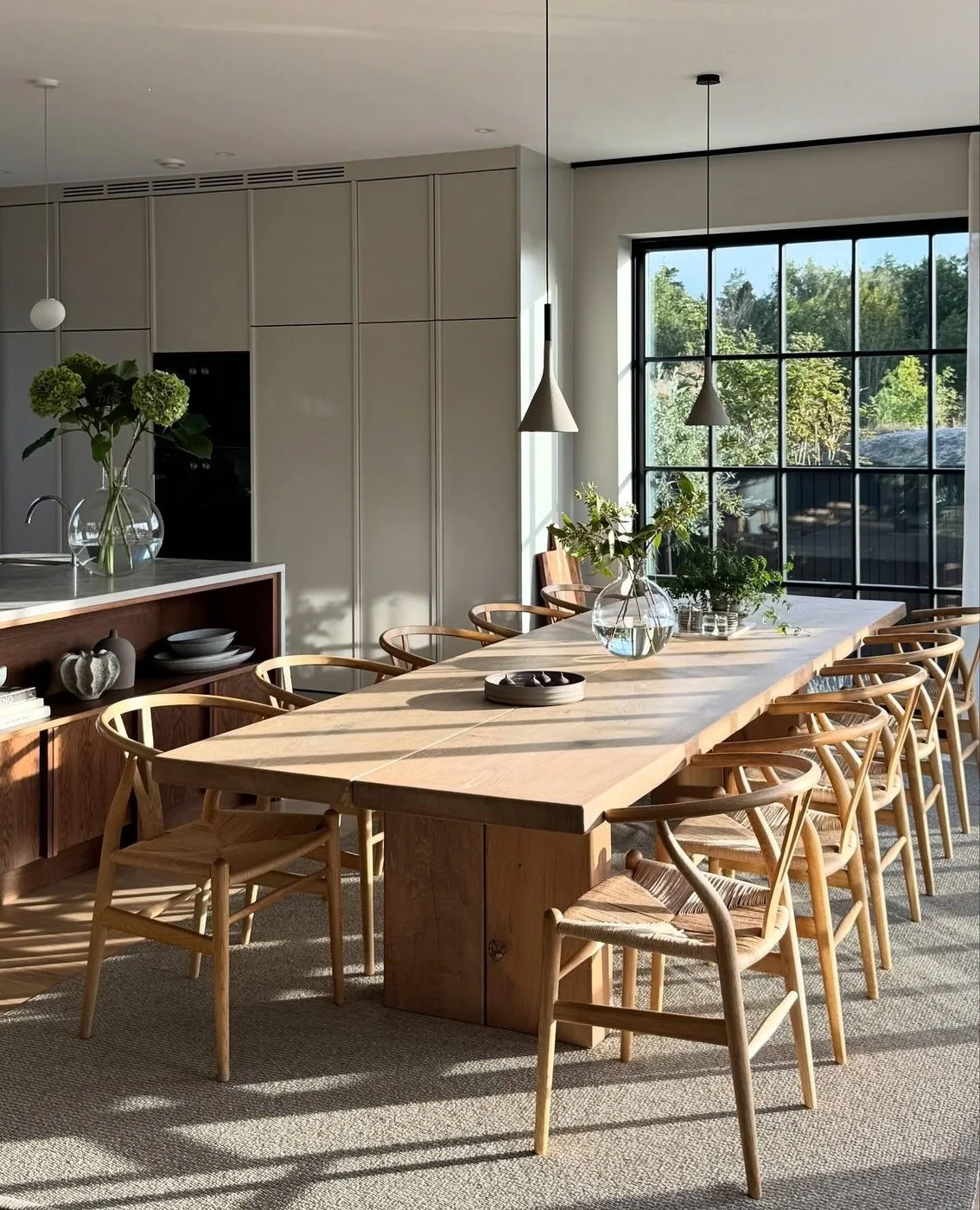 Long ash dining table and chairs in a bright modern interior