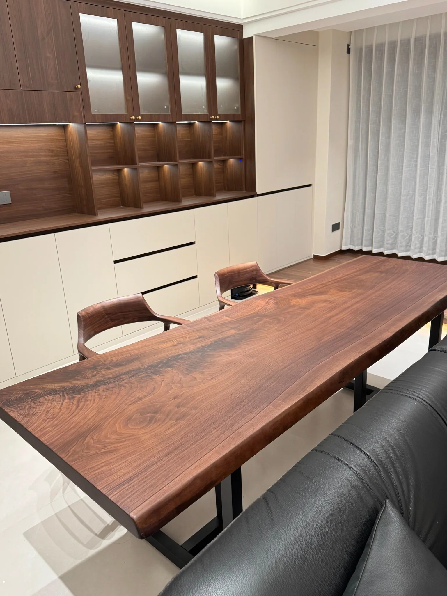 Large walnut dining table coordinated with walnut built-in cabinetry