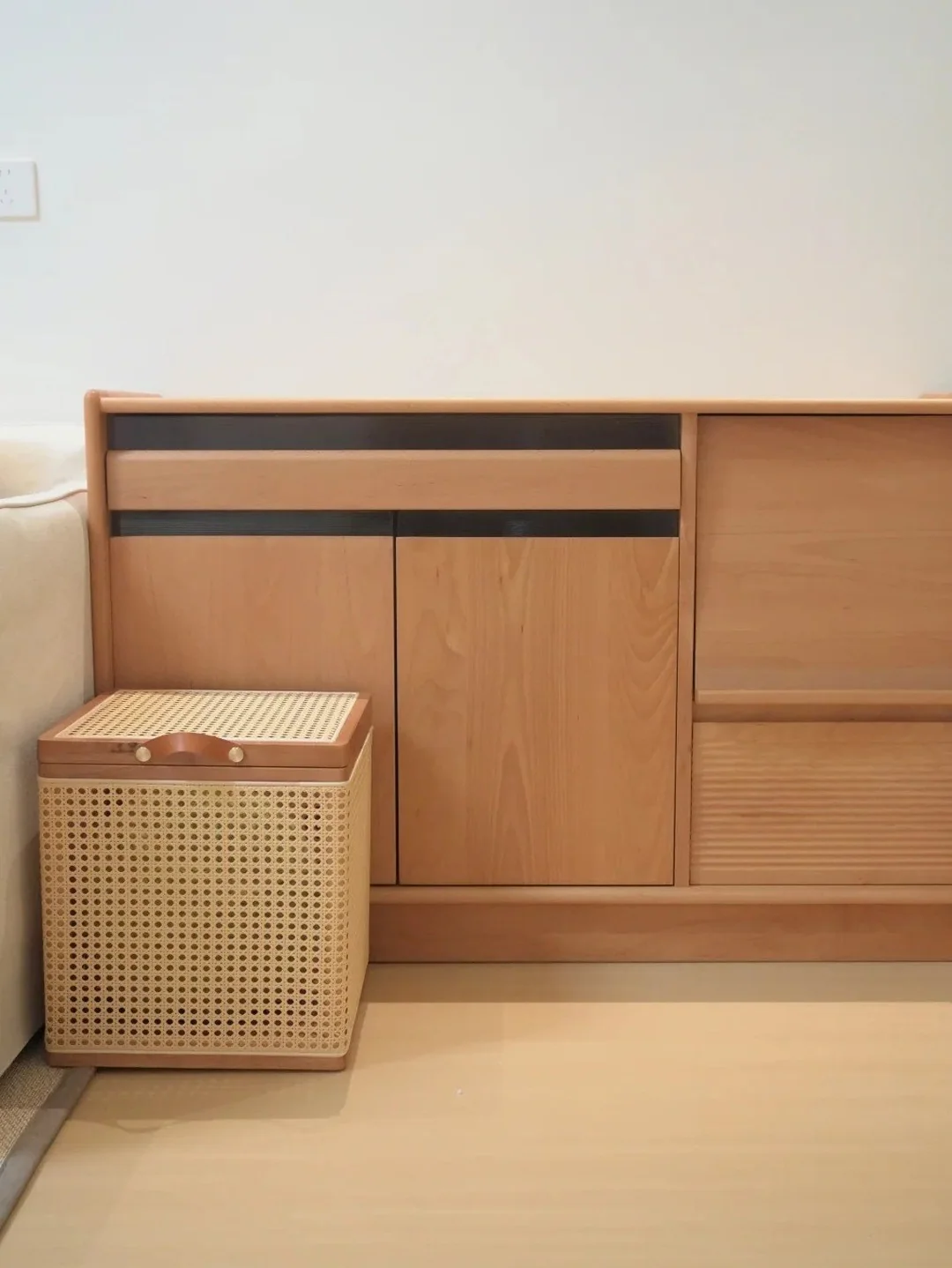 Light wood storage cabinet with woven basket