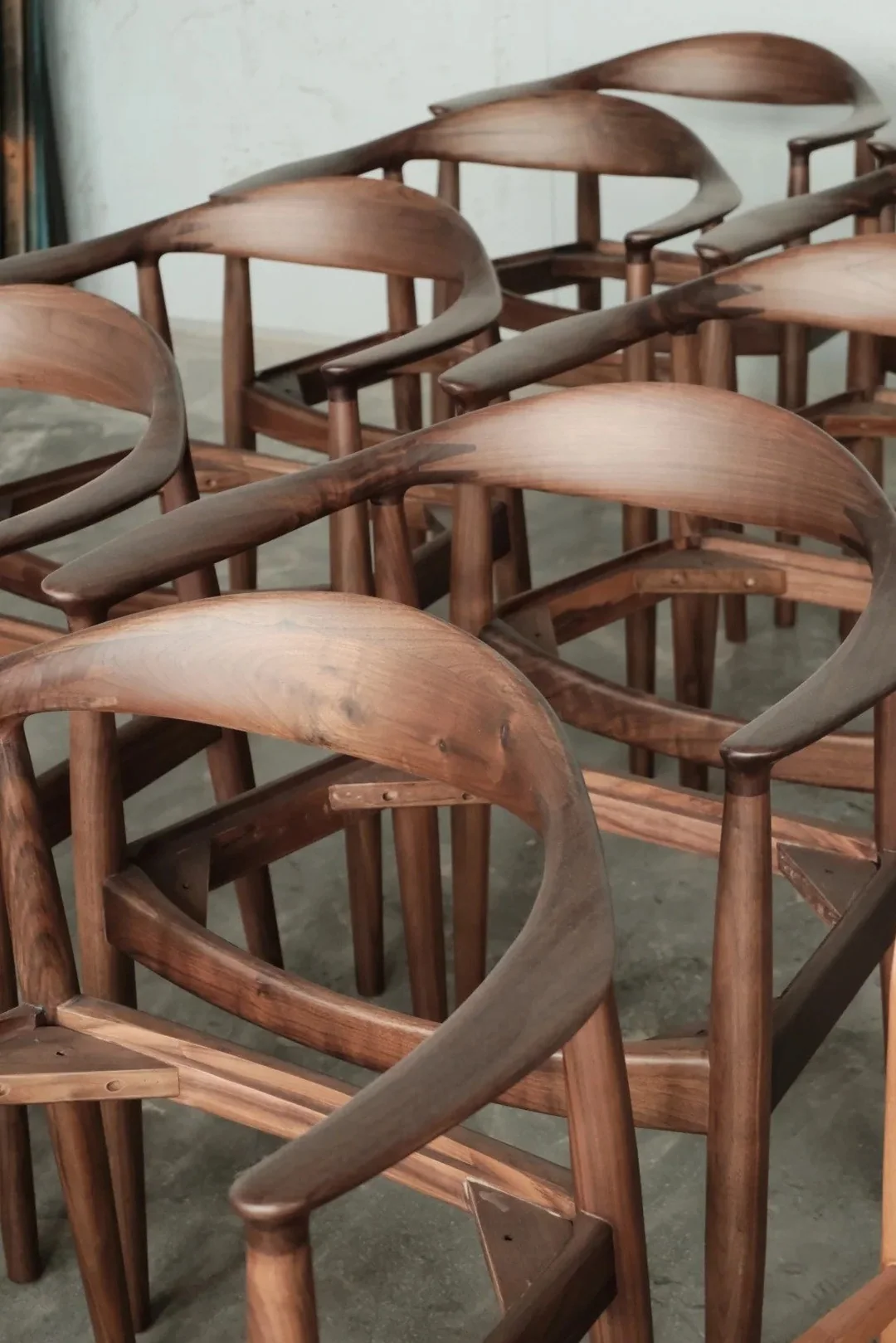 Dark finished curved wood chair frames in a production batch