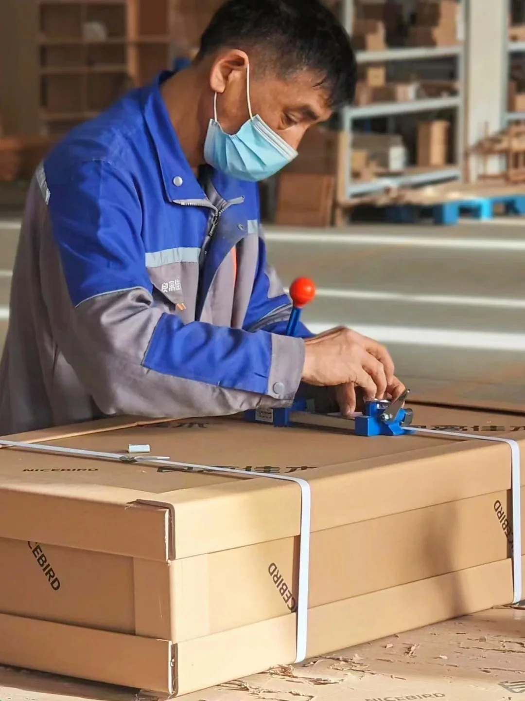 Factory worker securing packaged furniture for shipment