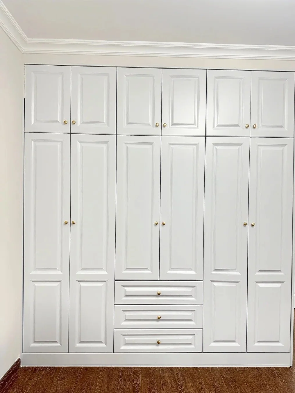White built-in wardrobe with detailed painted doors