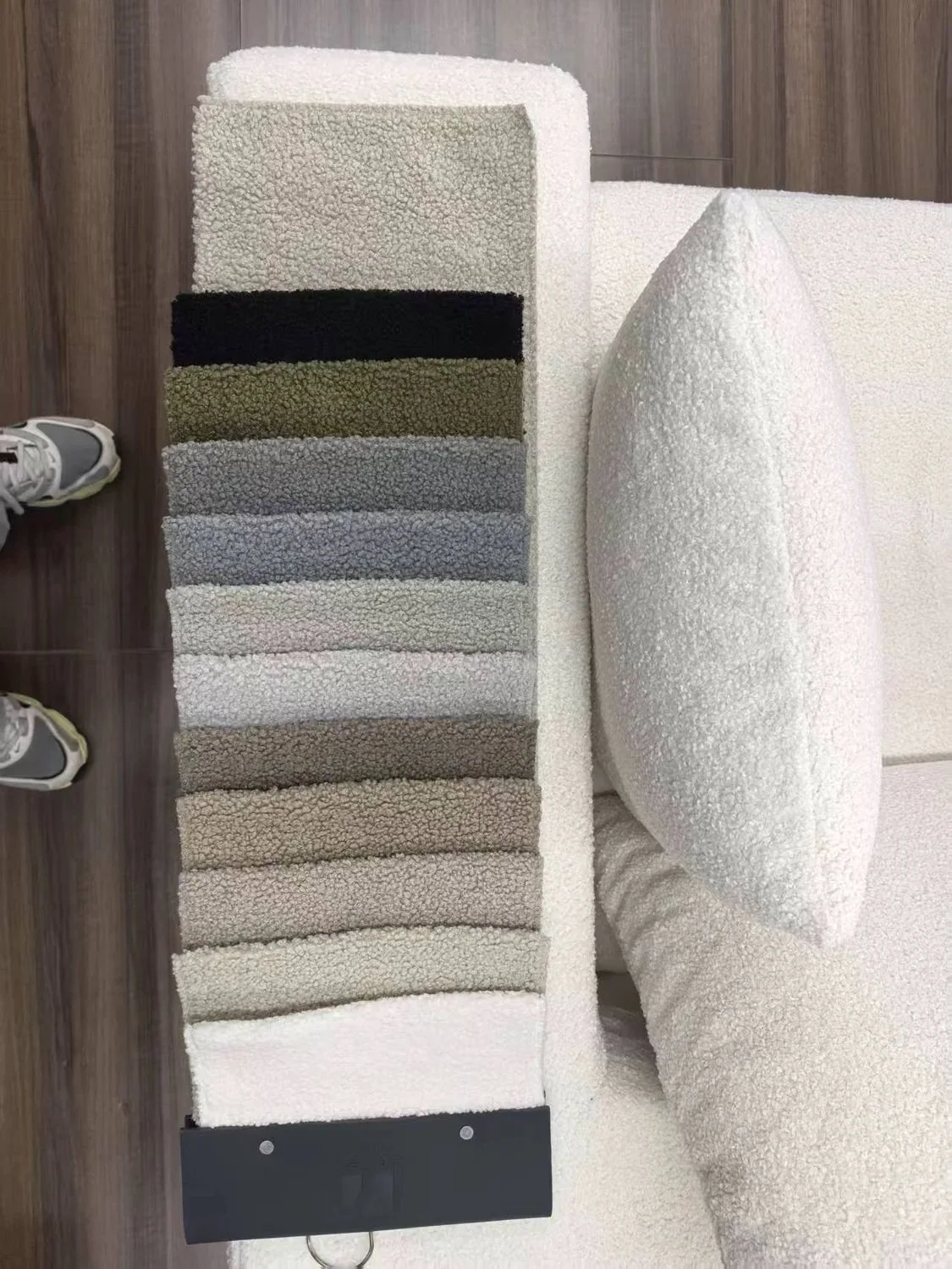 Bouclé upholstery swatch card next to a white upholstered seat