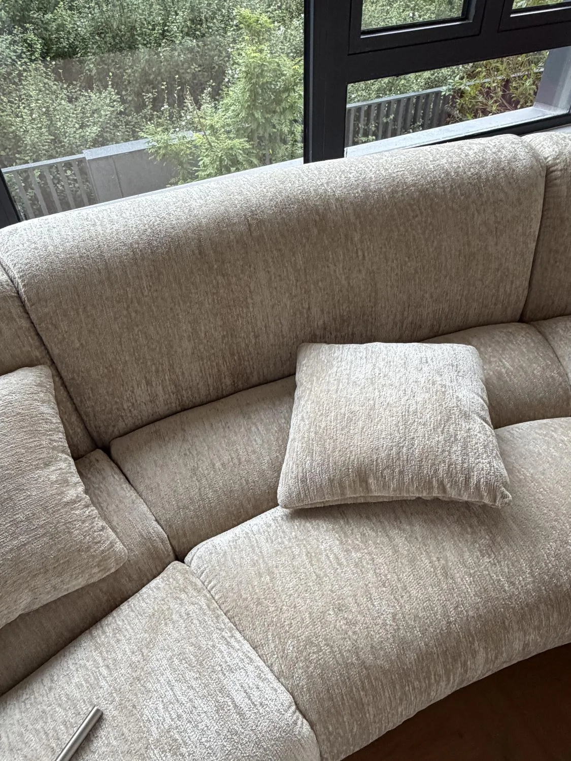 Neutral chenille sofa with cushion in daylight