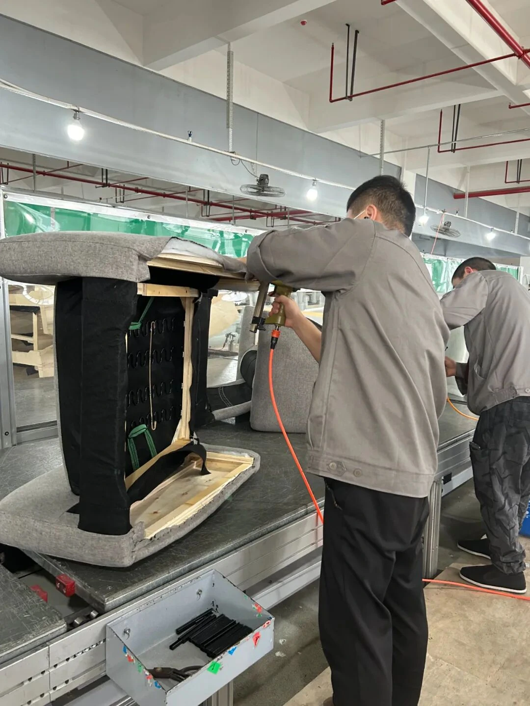 Factory worker inspecting sofa mechanism