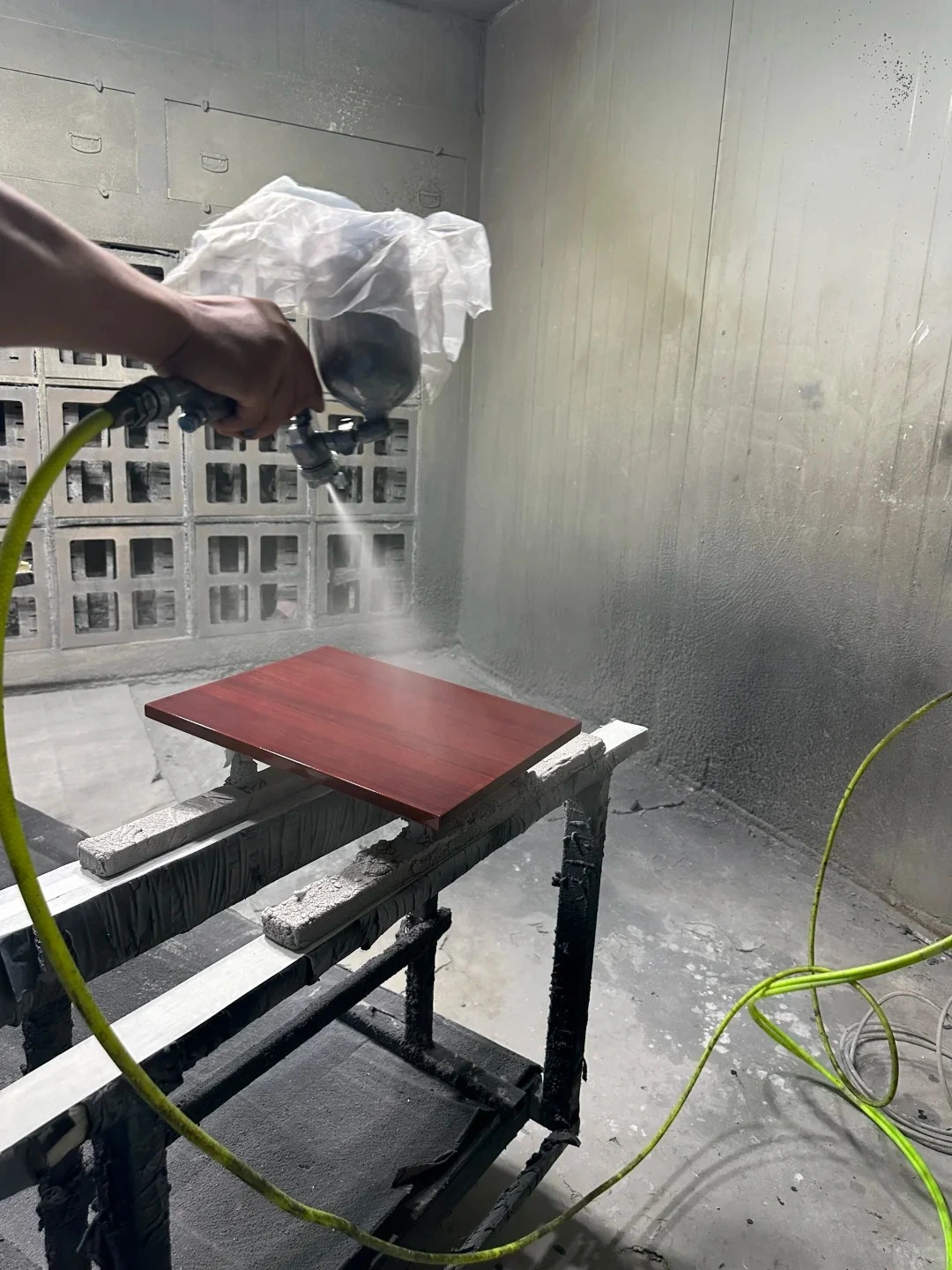 Furniture panel being spray finished in a spray booth