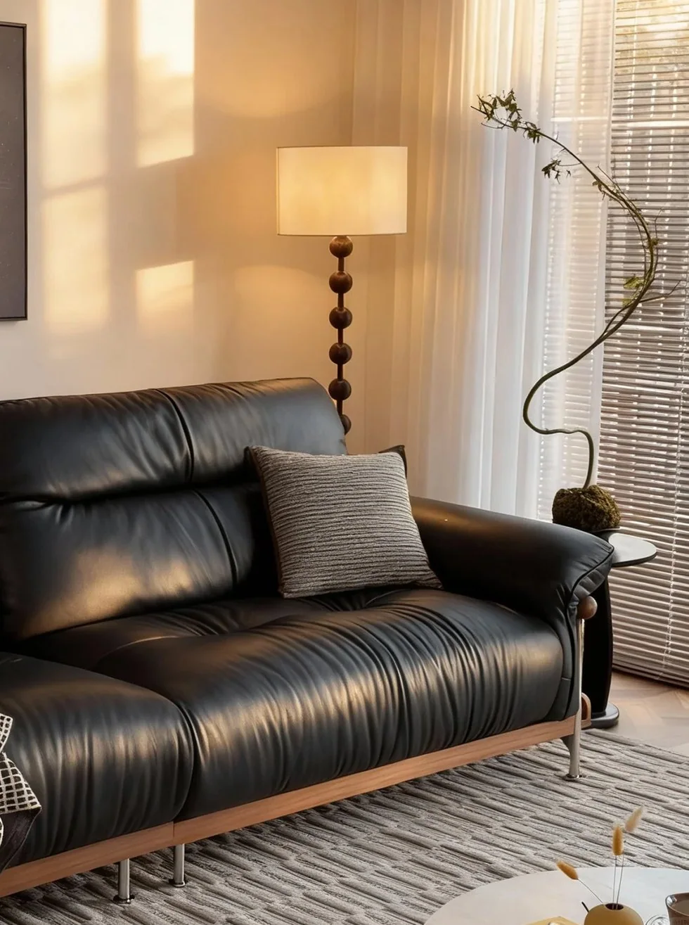 Modern black leather sofa in a sunlit living room