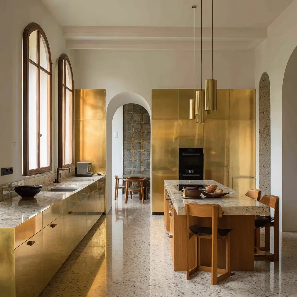 Large brass-toned cabinet fronts create a much stronger visual statement and require careful color control across panels.
