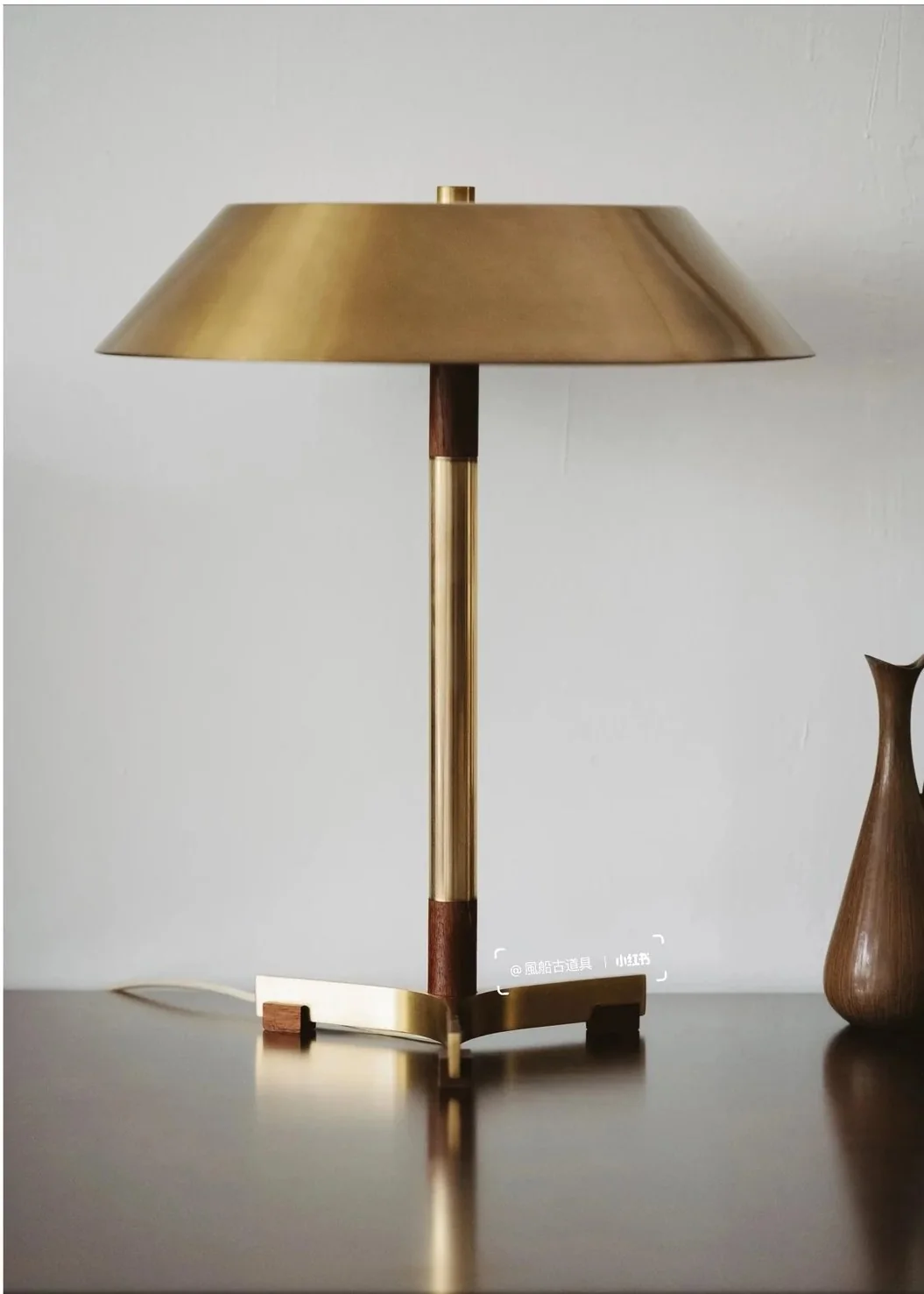 A satin brass lamp illustrates how a controlled low-sheen finish can feel warm without looking glossy.