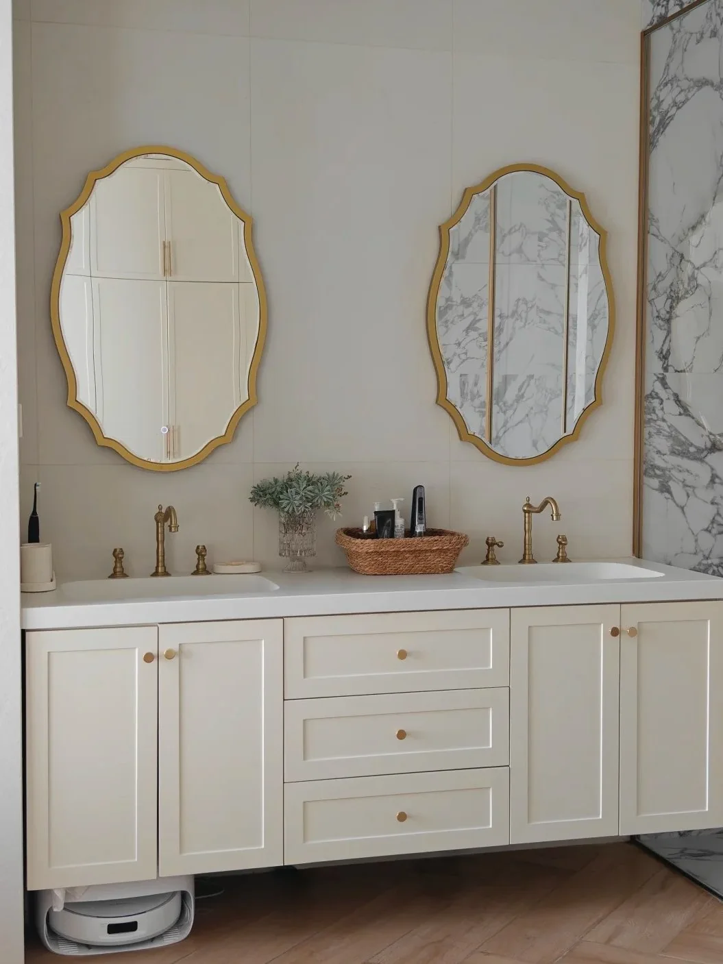 Brass mirror frames and hardware warm up a light vanity without needing large metal surfaces.