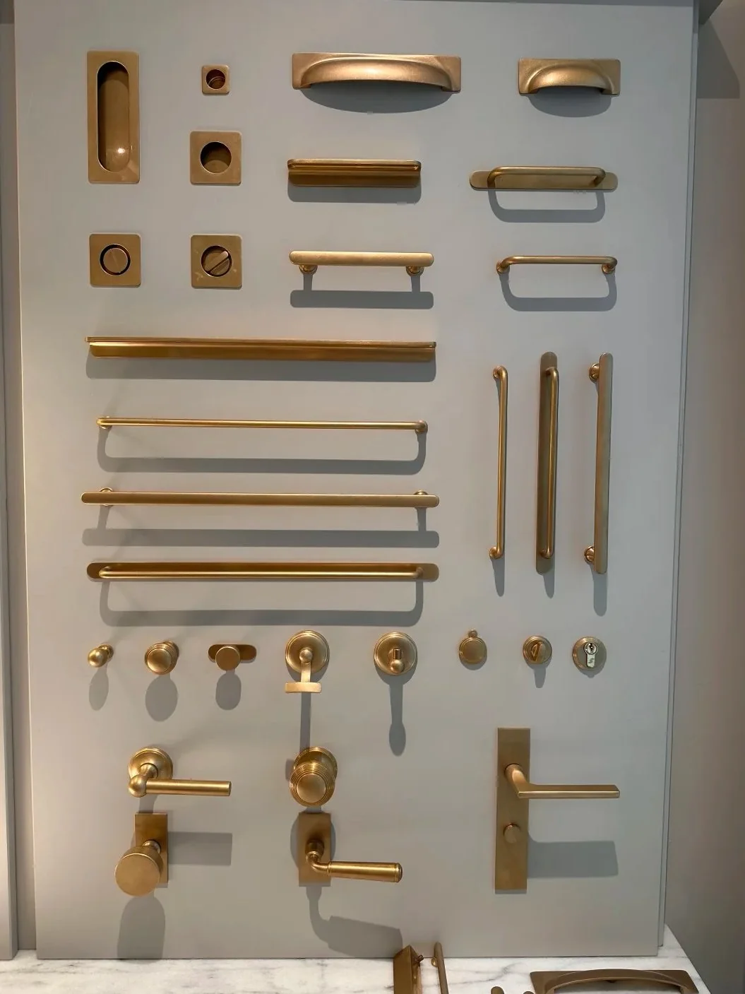 A controlled hardware family can repeat the same warm metal language across multiple furniture types.