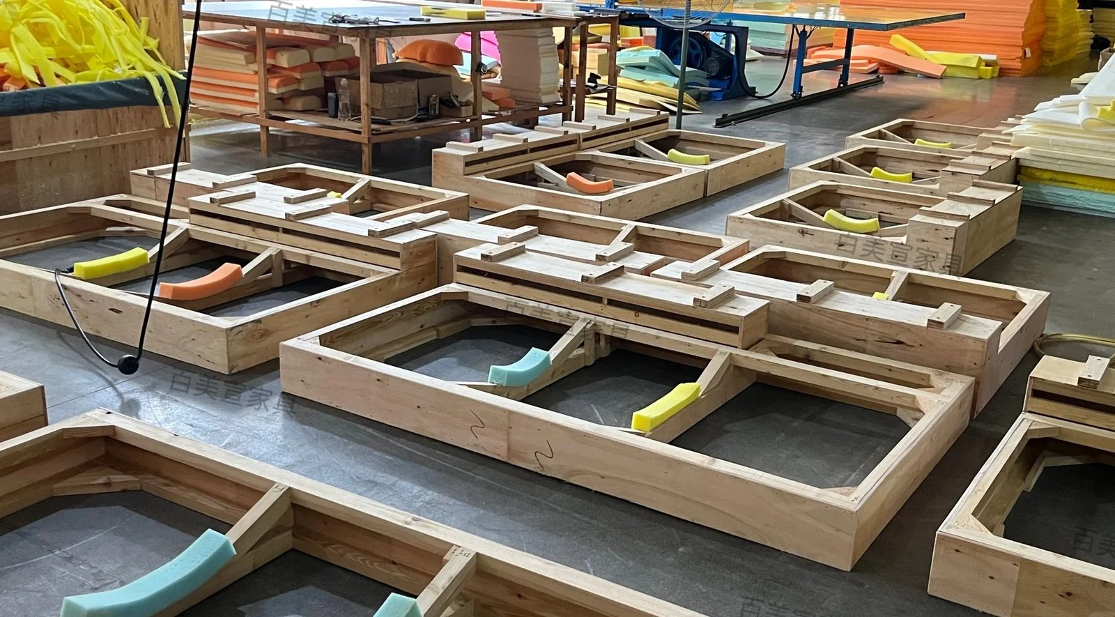 Multiple sofa timber frames laid out in a workshop