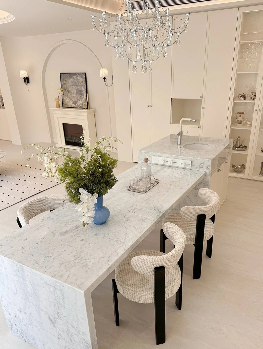 Large waterfall stone kitchen island in a bright interior