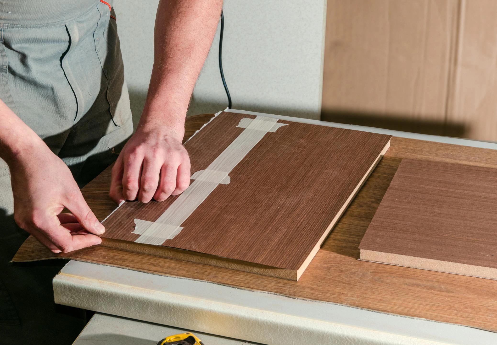 Craftsperson positioning veneer by hand