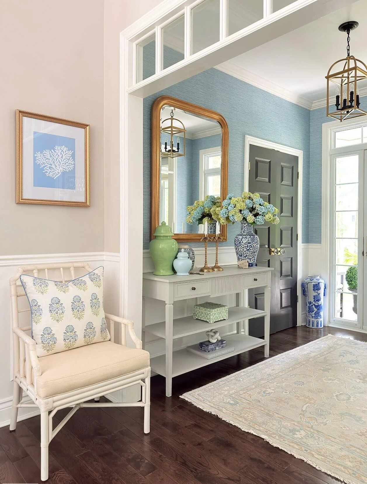 Coastal entryway with a bench, pale paneling and an arched doorway