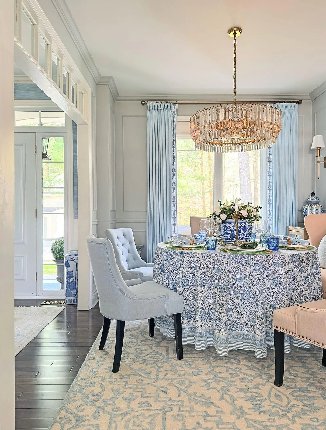 Coastal dining room with patterned blue chairs and a woven pendant