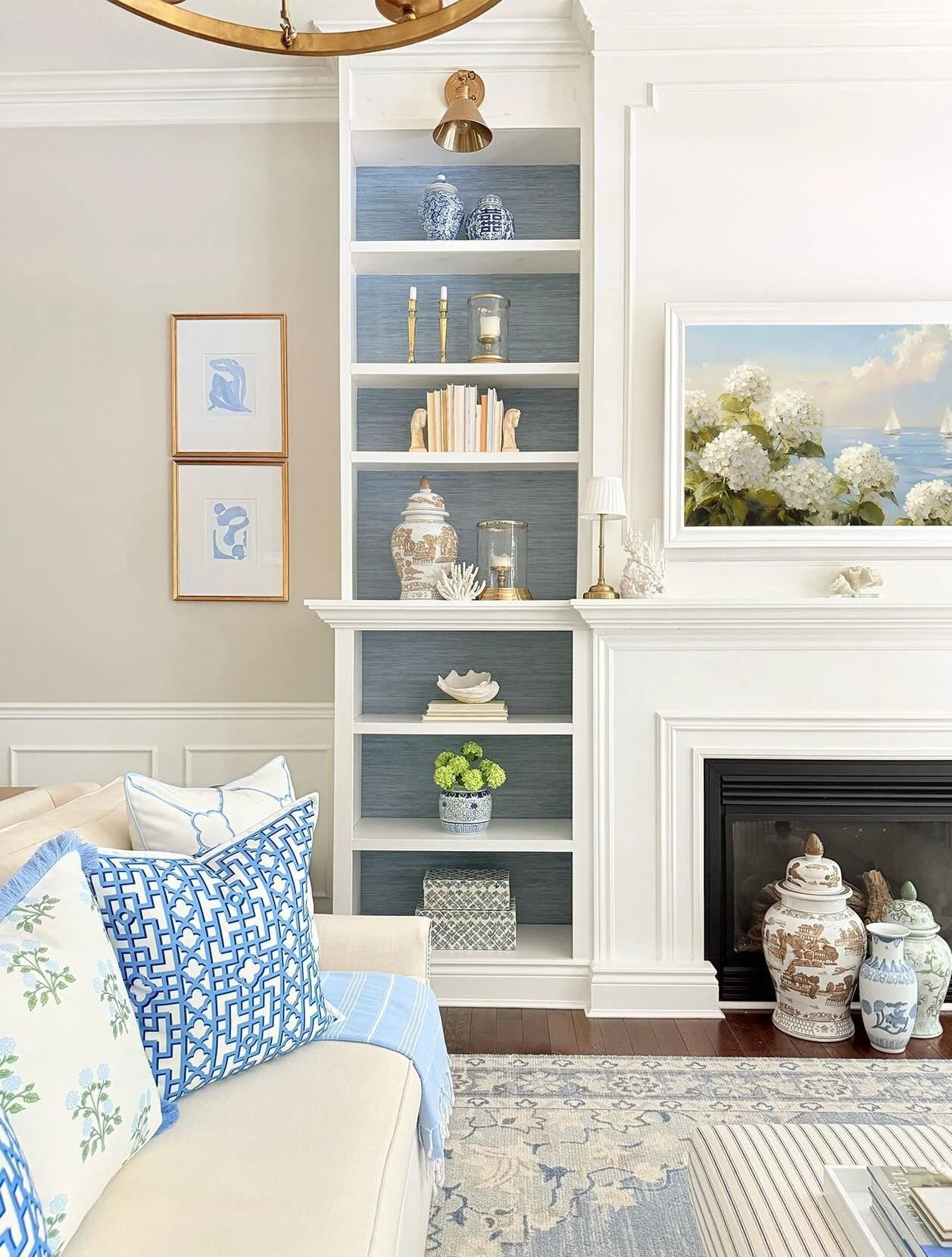 Coastal living room with blue cushions, built-in shelves and a fireplace