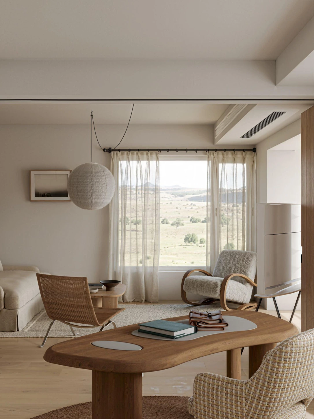 Japandi living room with low wood coffee table, woven lounge chair and warm neutral furnishings