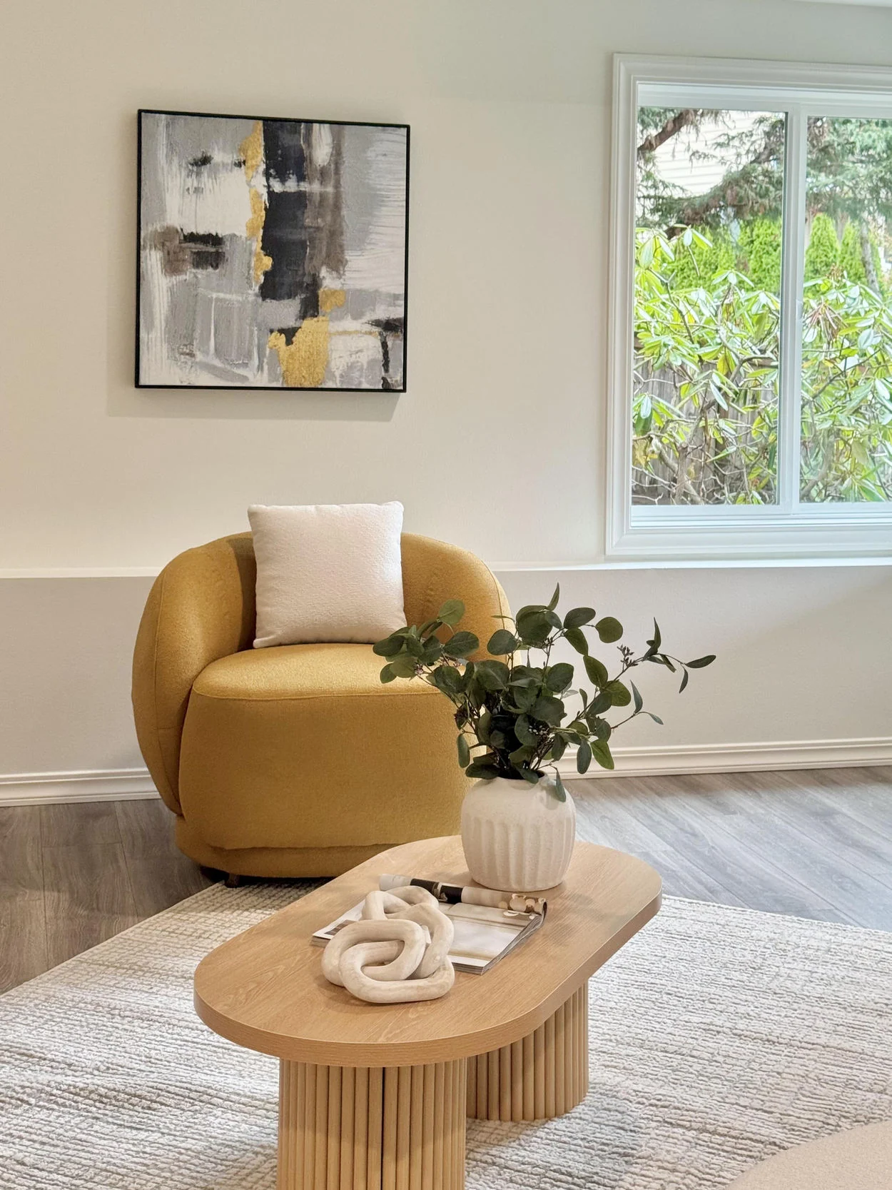 Ochre lounge chair and organic-shaped coffee table in a bright living room