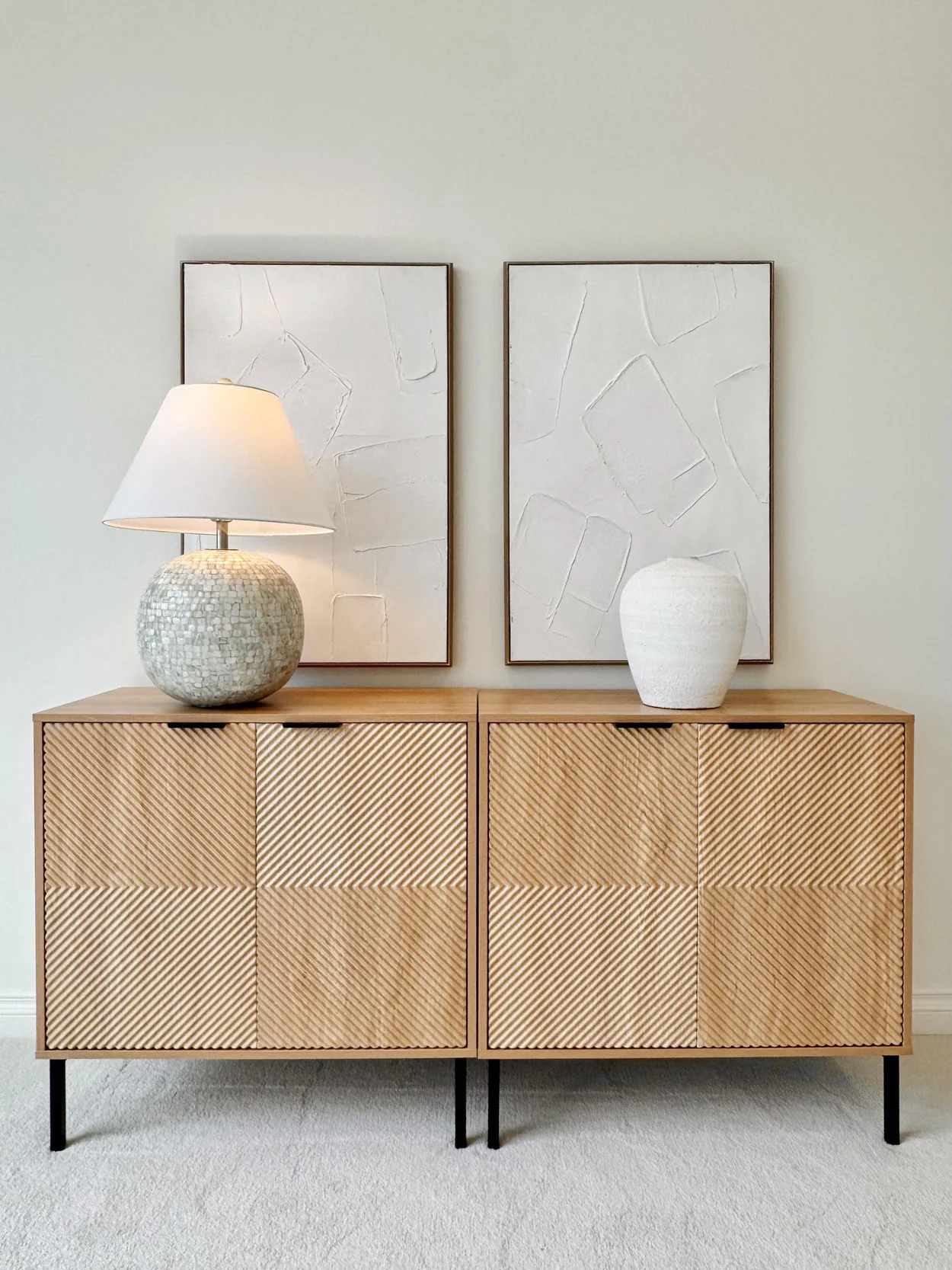 Light wood sideboard with textured woven cabinet doors and simple ceramic decor