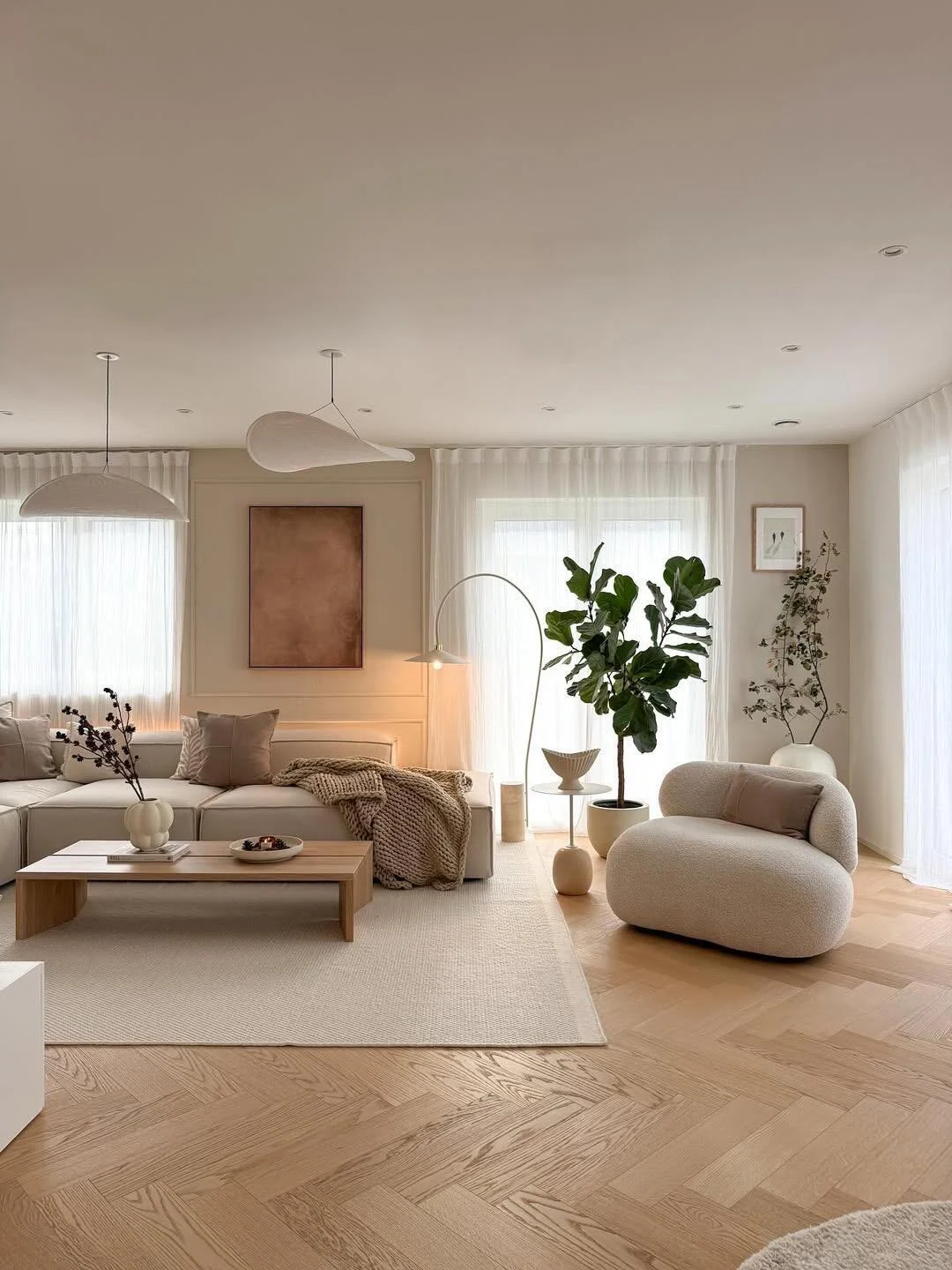 Wide Scandinavian living room with cream sofa, wood coffee table, soft daylight and pale parquet flooring