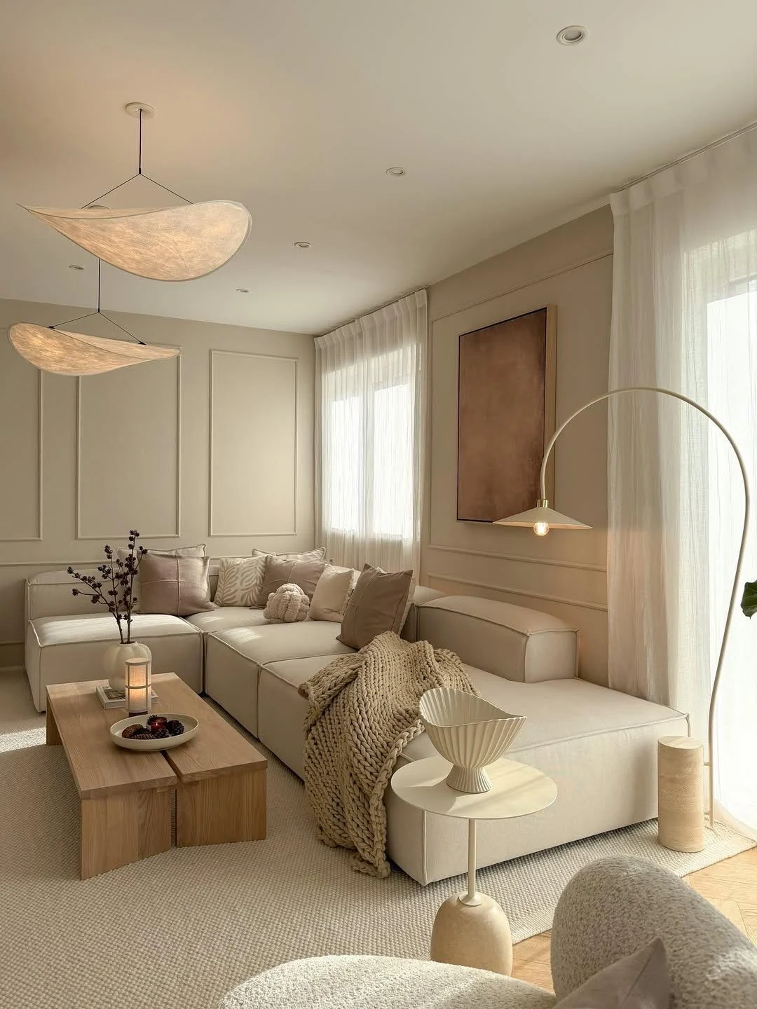 Scandinavian modular sofa, wood coffee table, warm textiles and slim curved floor lamp in a sunlit living room