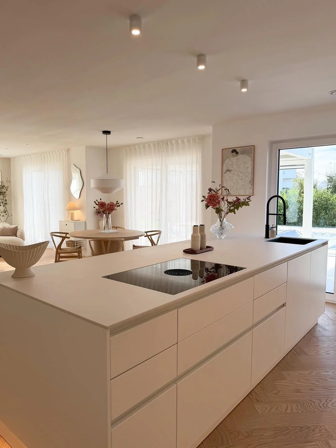 Minimal Scandinavian kitchen with pale cabinetry, waterfall island and uncluttered work surfaces